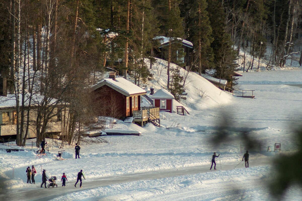 Perhe hiihtämässä talvisessa maisemassa